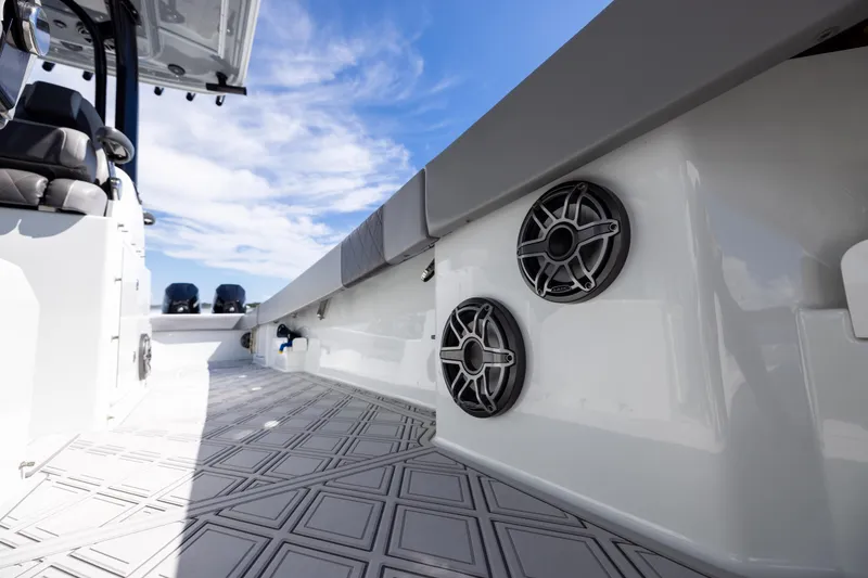 Slide: The Image of 2023 Freeman 47 boat interior with speakers, sleek design, and patterned flooring under a blue sky. - 98