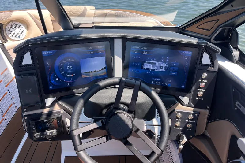 Slide: The Image of 2025 Centurion Ri230 boat dashboard with dual touchscreen displays and steering wheel. - 2
