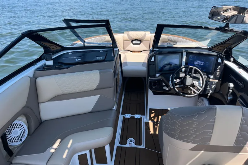 Slide: The Image of 2025 Centurion Ri230 boat interior with modern dashboard and comfortable seating on the water. - 4