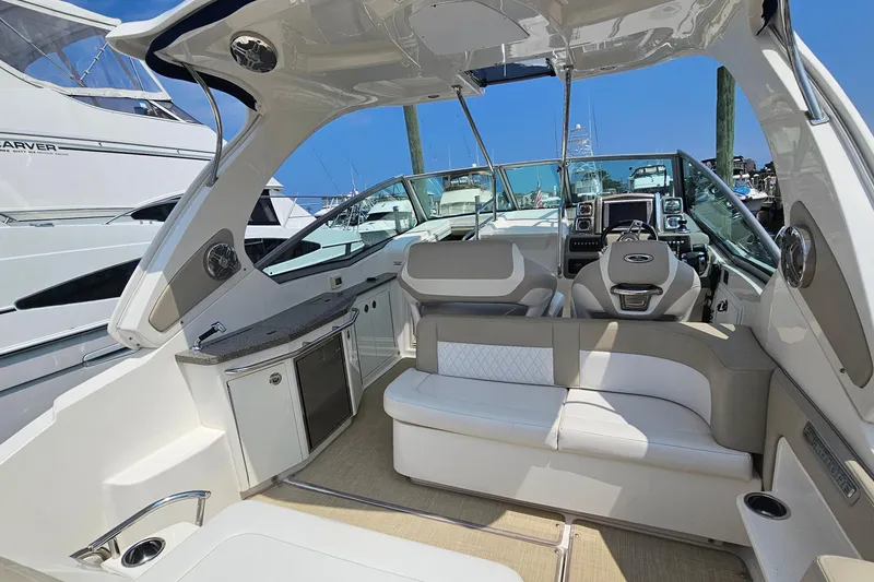 Slide: The Image of 2015 Chaparral 310 Signature boat interior with seating and helm, docked at marina. - 13