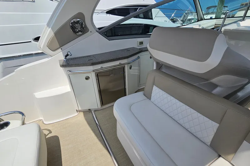 Slide: The Image of 2015 Chaparral 310 Signature boat interior with seating and kitchenette area. - 14