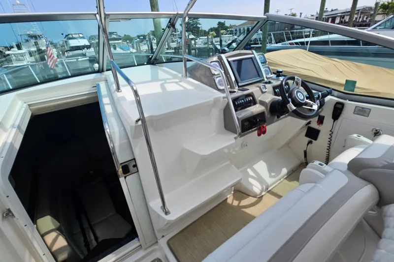 Slide: The Image of 2015 Chaparral 310 Signature boat cockpit with steering wheel and navigation controls. - 16