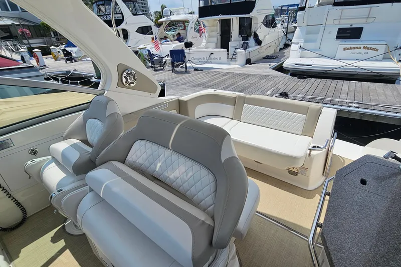 Slide: The Image of 2015 Chaparral 310 Signature boat interior with plush seating at a marina. - 18