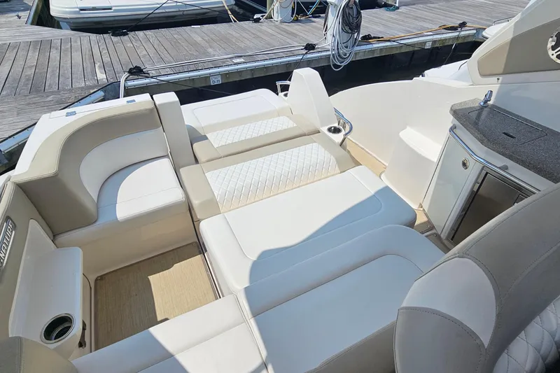 Slide: The Image of 2015 Chaparral 310 Signature boat interior with luxurious seating and dock view. - 20