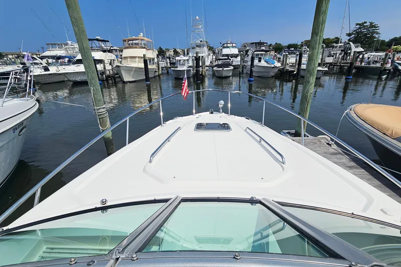 Slide: The Image of 2015 Chaparral 310 Signature yacht docked in a marina, surrounded by various boats. - 21