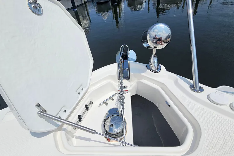 Slide: The Image of 2015 Chaparral 310 Signature boat anchor compartment with open hatch and polished metal fixtures. - 23