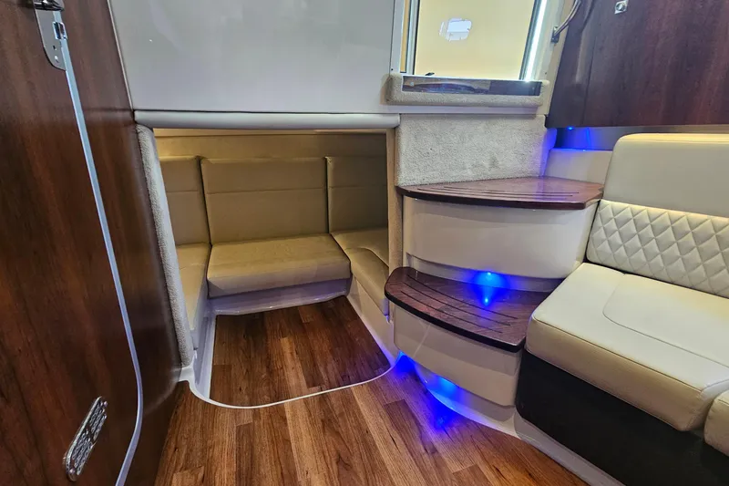 Slide: The Image of Interior of 2015 Chaparral 310 Signature boat with wood flooring and cushioned seating. - 30