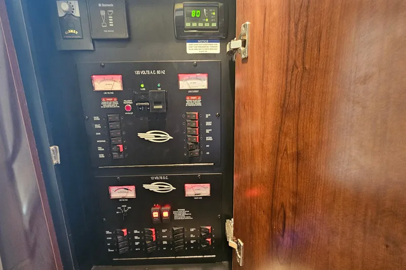 Slide: The Image of Electrical control panel inside 2015 Chaparral 310 Signature boat, featuring voltage meters and switches. - 33