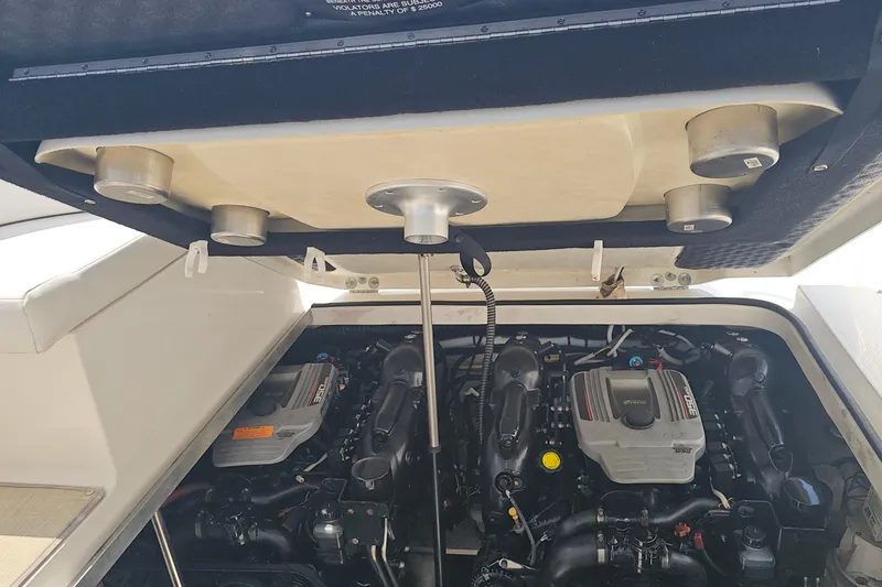 Slide: The Image of Engine compartment of a 2015 Chaparral 310 Signature boat, showcasing dual engines. - 37