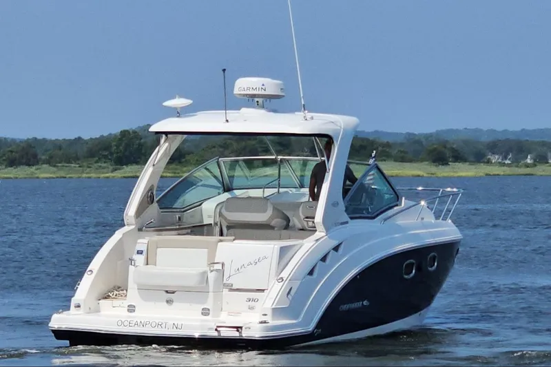 Slide: The Image of 2015 Chaparral 310 Signature boat cruising on a serene lake. - 5