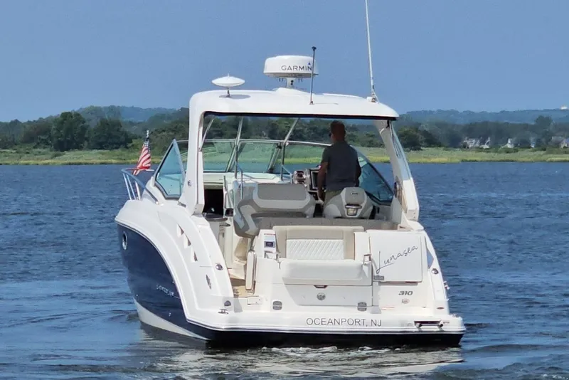 Slide: The Image of 2015 Chaparral 310 Signature boat cruising on a scenic waterway. - 7