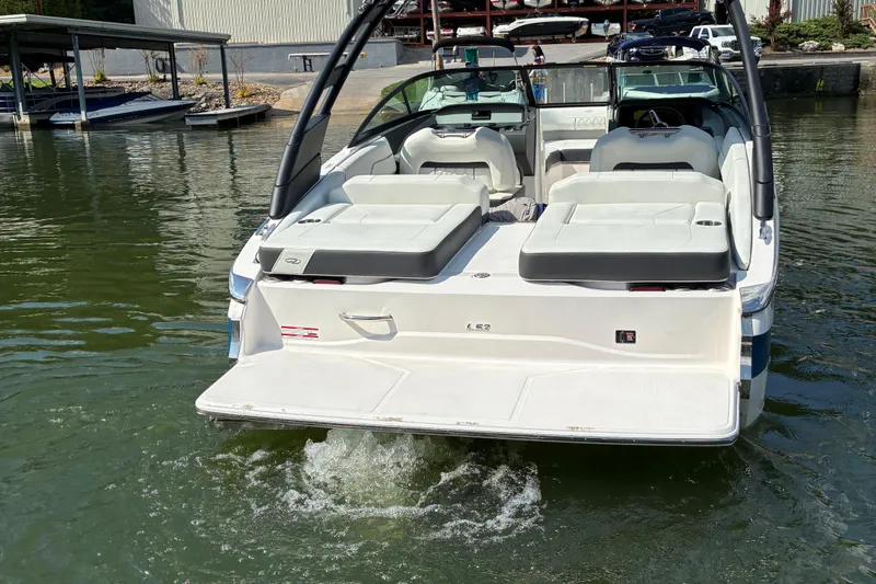 Slide: The Image of 2025 Regal LS2 boat with spacious seating, docked on calm water. - 11