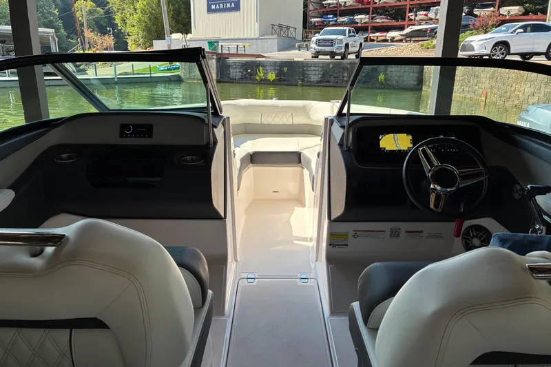 Slide: The Image of Interior view of 2025 Regal LS2 boat at marina, featuring modern dashboard and seating. - 23