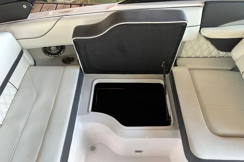 Slide: The Image of 2025 Regal LS2 boat interior with open storage compartment and cushioned seating. - 27