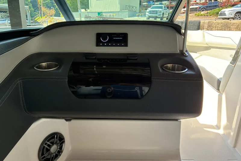 Slide: The Image of 2025 Regal LS2 boat interior with dashboard, cup holders, and speaker. - 29