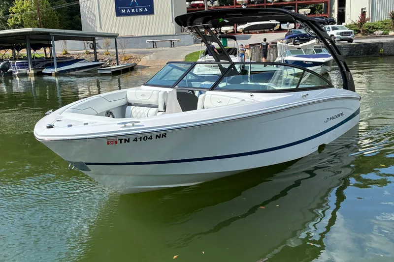 Slide: The Image of 2025 Regal LS2 boat docked at marina, sleek white design, calm water setting. - 3