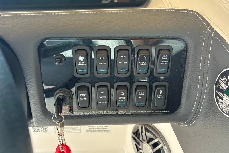 Slide: The Image of Control panel of a 2025 Regal LS2 boat with various switches and key ignition. - 31
