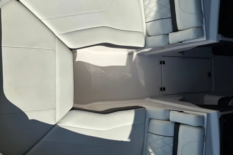 Slide: The Image of 2025 Regal LS2 boat interior with white leather seating and storage compartment. - 41