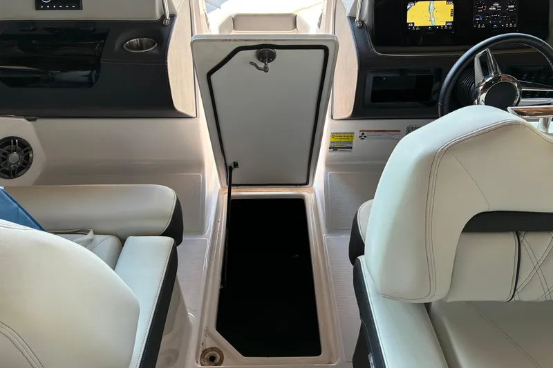 Slide: The Image of Interior of 2025 Regal LS2 boat with open storage compartment and modern dashboard. - 46