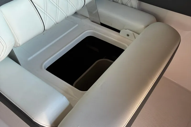 Slide: The Image of 2025 Regal LS2 boat interior with open storage compartment under white cushioned seating. - 47
