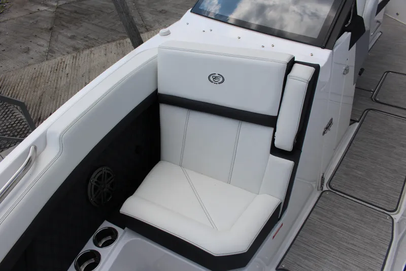 Slide: The Image of 2025 Cobalt R8 boat interior with white cushioned seating and cup holders. - 12