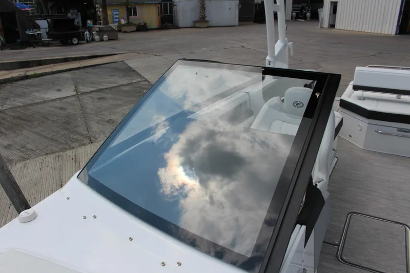 Slide: The Image of 2025 Cobalt R8 boat windshield reflecting cloudy sky at a marina. - 13