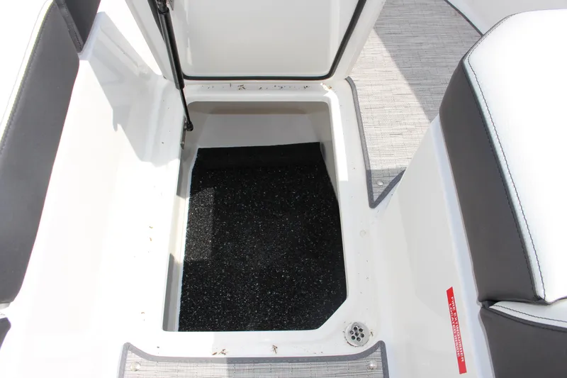 Slide: The Image of Open storage compartment in 2025 Cobalt R8 boat, featuring black interior and white exterior. - 19