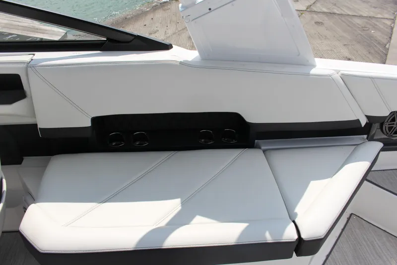 Slide: The Image of 2025 Cobalt R8 boat interior with white seating and cup holders by the water. - 30