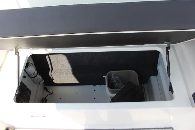 Slide: The Image of Open storage compartment in 2025 Cobalt R8 boat with fire extinguisher and container. - 37