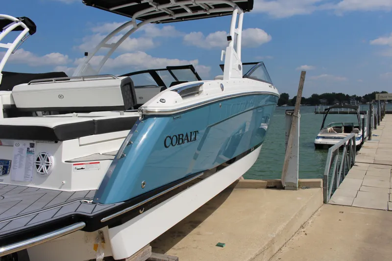 Slide: The Image of 2025 Cobalt R8 boat docked by the lake under a clear blue sky. - 4