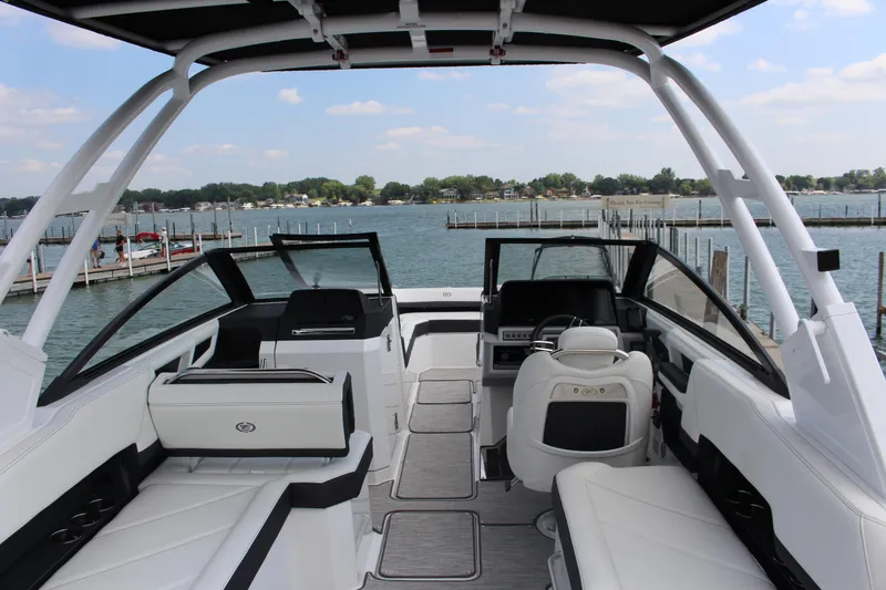 Slide: The Image of 2025 Cobalt R8 boat interior with luxurious seating and modern design on a scenic lake. - 9