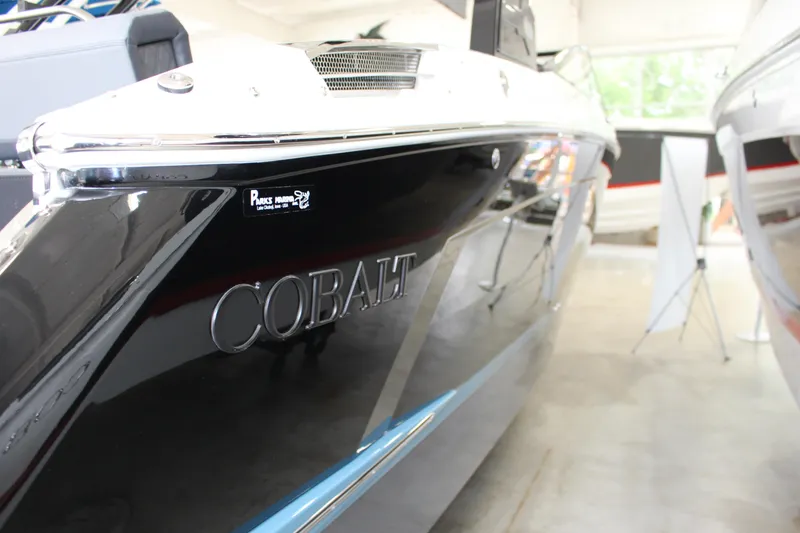 Slide: The Image of 2025 Cobalt R6 boat in showroom, sleek black exterior with chrome accents. - 17