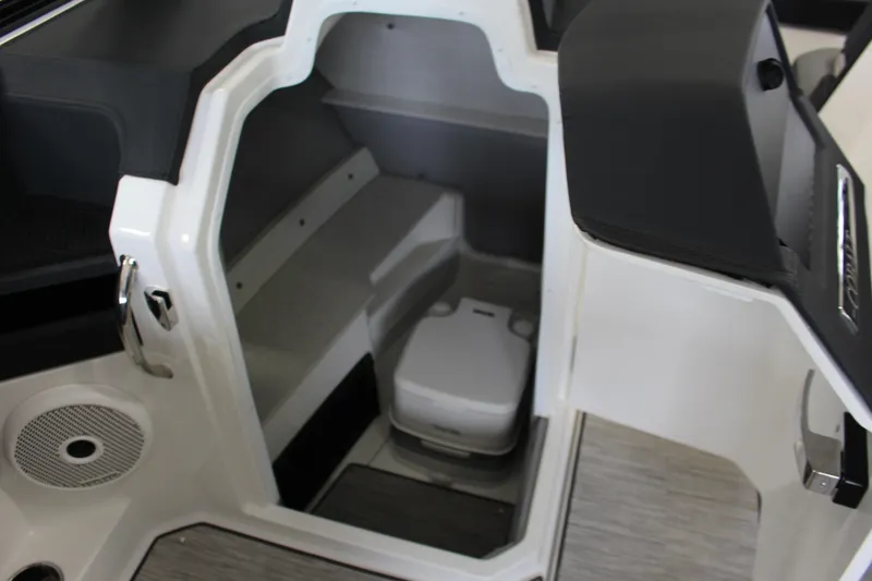 Slide: The Image of 2025 Cobalt R6 boat interior with compact marine toilet and storage area. - 7