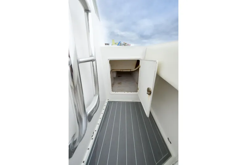 Slide: The Image of 2008 Venture 39 Cuddy boat interior storage compartment with open door, showcasing sleek design. - 15