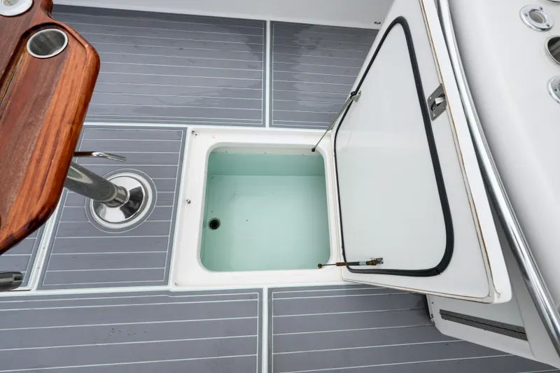 Slide: The Image of Open storage compartment on 2008 Venture 39 Cuddy boat deck with gray flooring. - 21