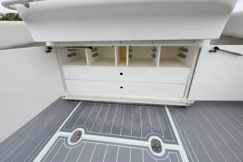 Slide: The Image of 2008 Venture 39 Cuddy boat storage compartments with open doors and gray deck flooring. - 22