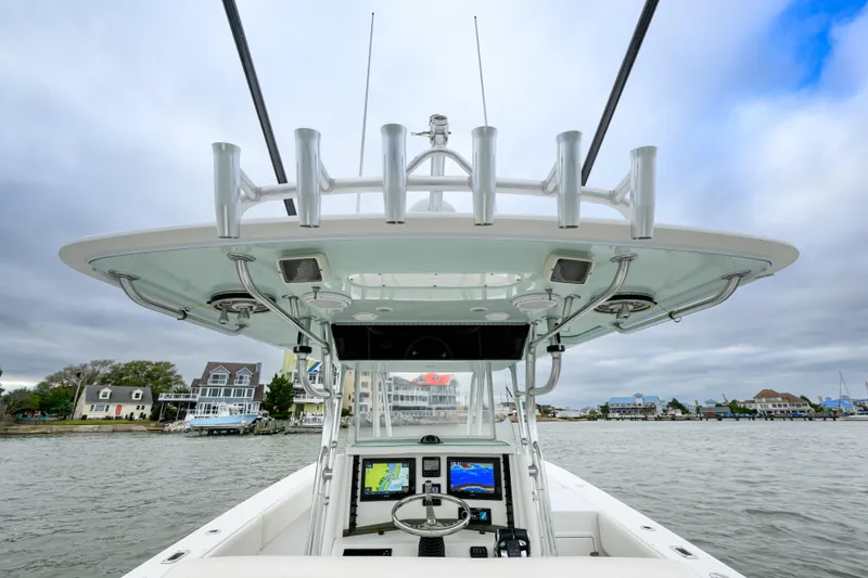 Slide: The Image of 2008 Venture 39 Cuddy boat helm with navigation screens, docked near waterfront homes. - 17