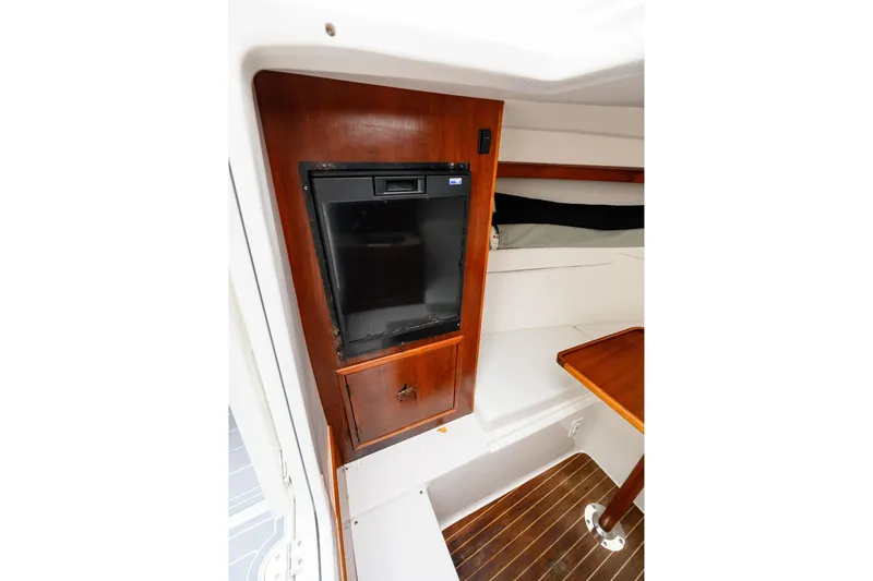 Slide: The Image of 2008 Venture 39 Cuddy cabin interior with wood paneling and compact fridge. - 25