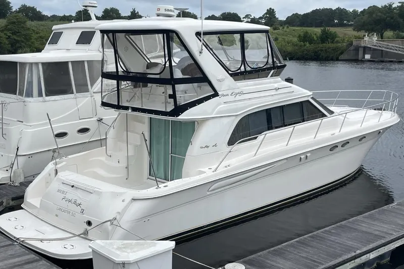 Slide: The Image of 1998 Sea Ray 480 Sedan Bridge yacht docked at marina, side view. - 0
