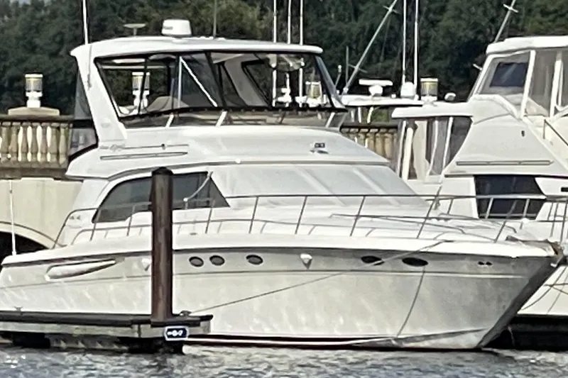 Slide: The Image of 1998 Sea Ray 480 Sedan Bridge yacht docked at marina, surrounded by other boats. - 1
