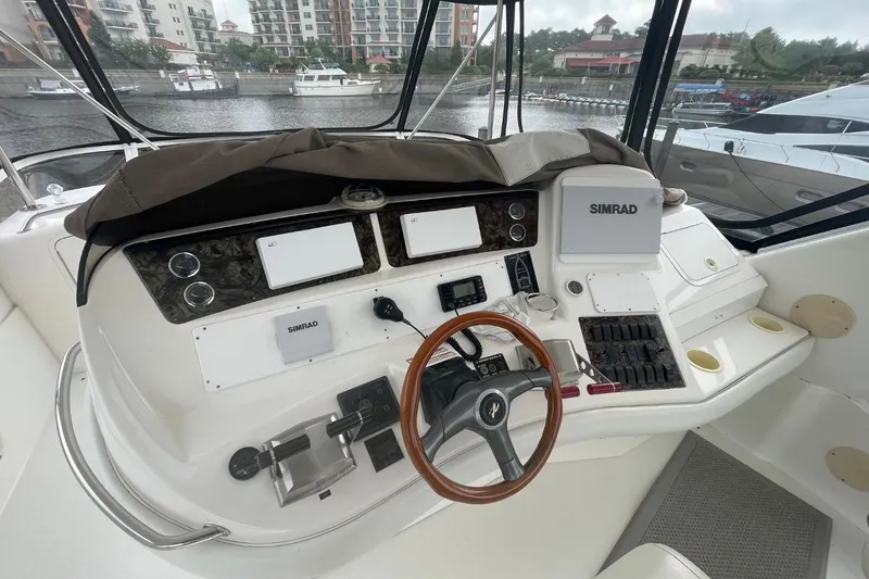 Slide: The Image of 1998 Sea Ray 480 Sedan Bridge helm with Simrad electronics and wooden steering wheel. - 10