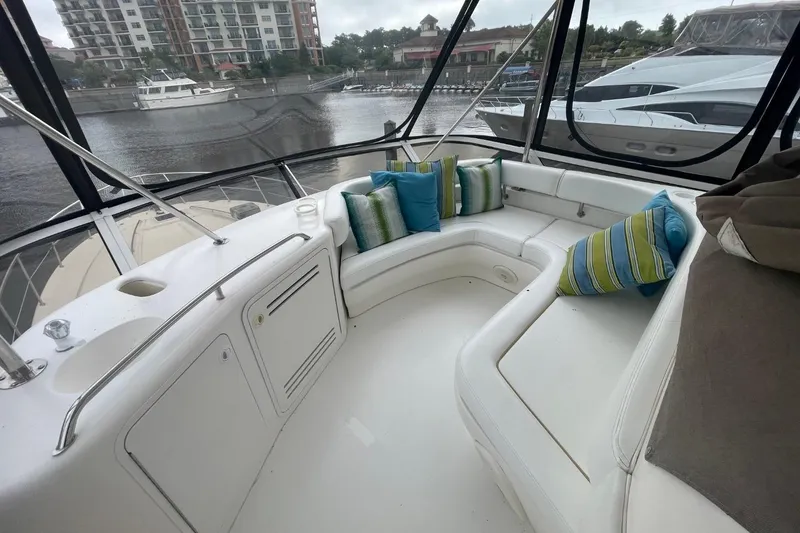 Slide: The Image of 1998 Sea Ray 480 Sedan Bridge interior with white seating and colorful cushions. - 11