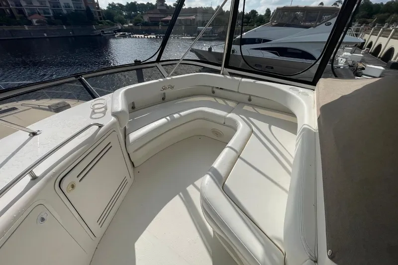 Slide: The Image of 1998 Sea Ray 480 Sedan Bridge yacht interior with white seating and waterfront view. - 19