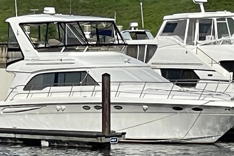 Slide: The Image of 1998 Sea Ray 480 Sedan Bridge yacht docked at marina, side view. - 2