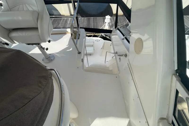 Slide: The Image of 1998 Sea Ray 480 Sedan Bridge interior with white seating and helm area. - 22