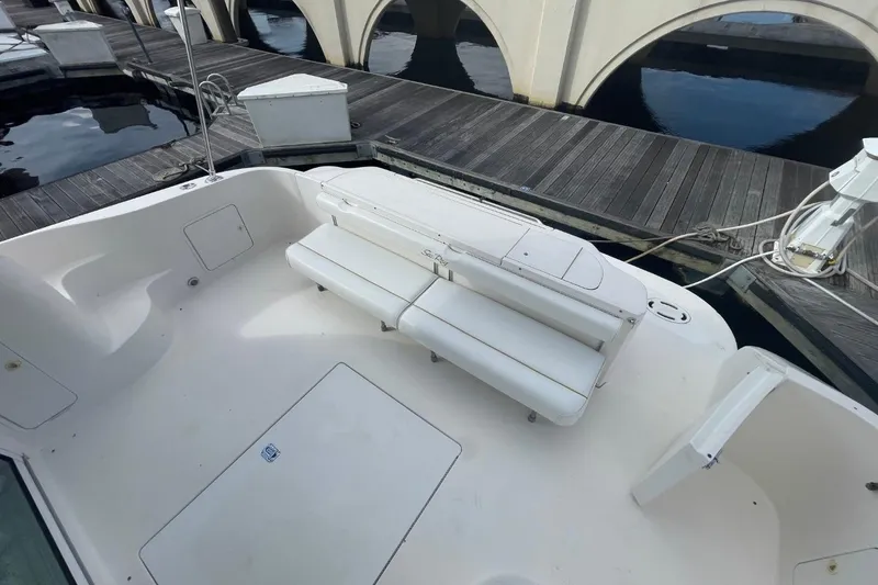 Slide: The Image of 1998 Sea Ray 480 Sedan Bridge boat with white seating and dock view. - 25