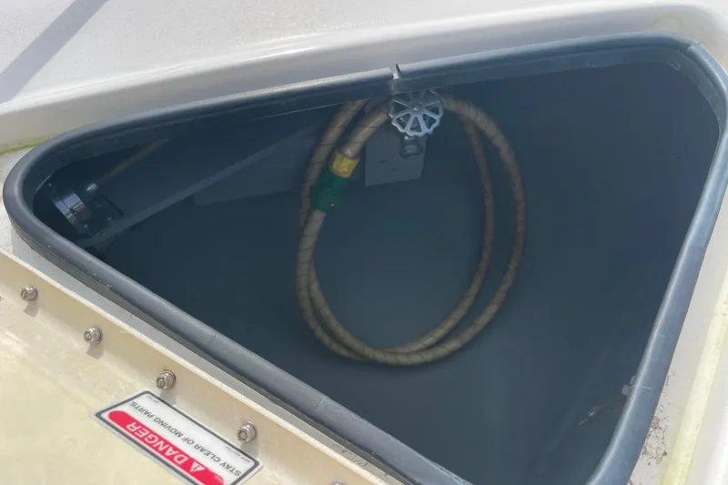 Slide: The Image of Open storage compartment on 1998 Sea Ray 480 Sedan Bridge boat with coiled rope inside. - 28