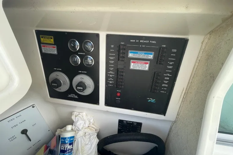 Slide: The Image of 1998 Sea Ray 480 Sedan Bridge control panel with gauges and cleaning supplies. - 30