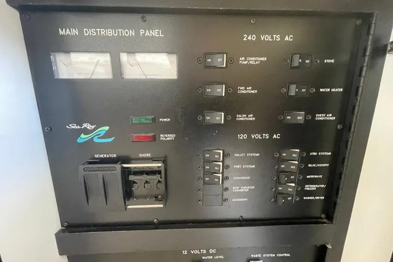 Slide: The Image of Main distribution panel of 1998 Sea Ray 480 Sedan Bridge yacht, showing AC and DC controls. - 33