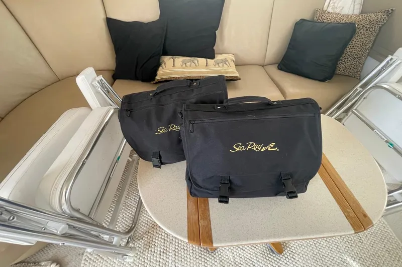 Slide: The Image of 1998 Sea Ray 480 Sedan Bridge interior with branded bags and folding chairs. - 34